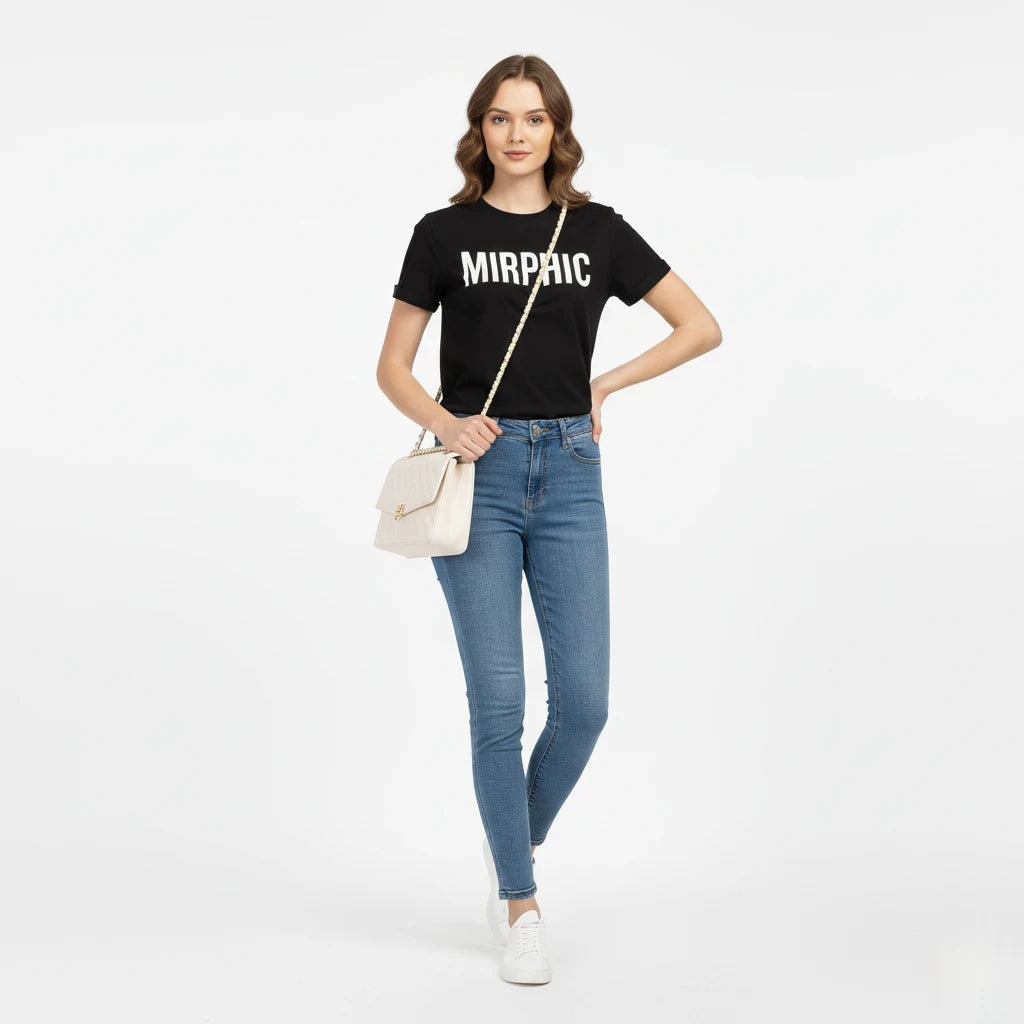 Woman wearing a black t-shirt with 'MIRPHIC' text, blue jeans, and white sneakers on a white background.