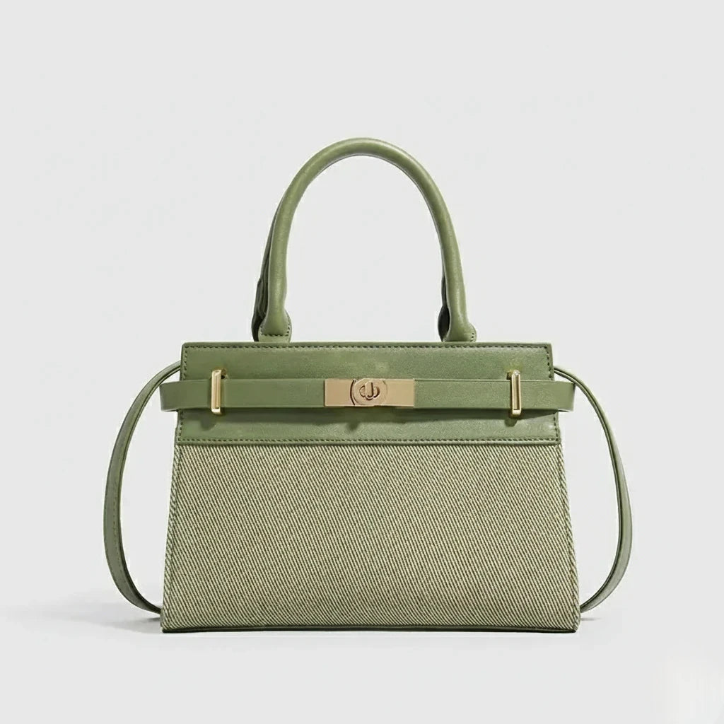 Green handbag with gold accents on a light gray background