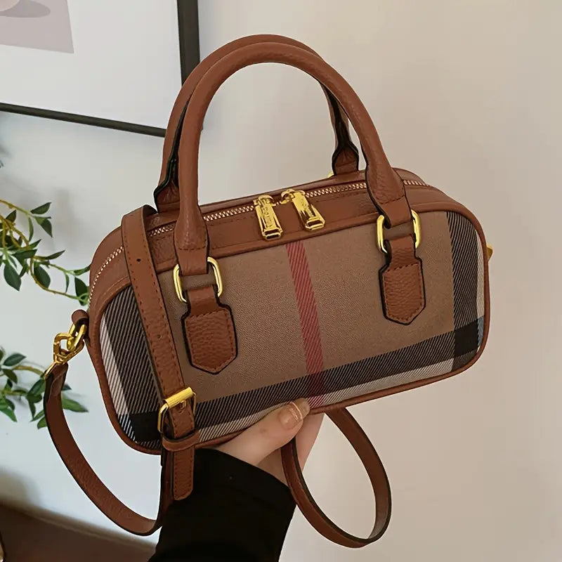 Brown handbag with check pattern held by a person, blurred background