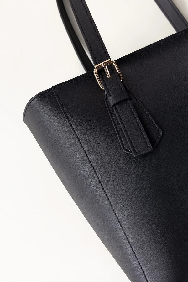 Black handbag with a gold buckle on a white background
