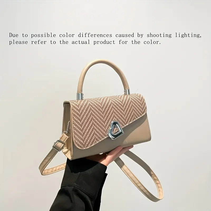 Handbag held by a person against a plain background