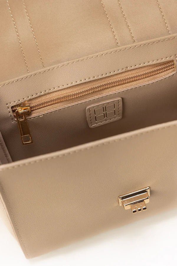 Close-up of a beige handbag with a gold zipper and clasp on a white background