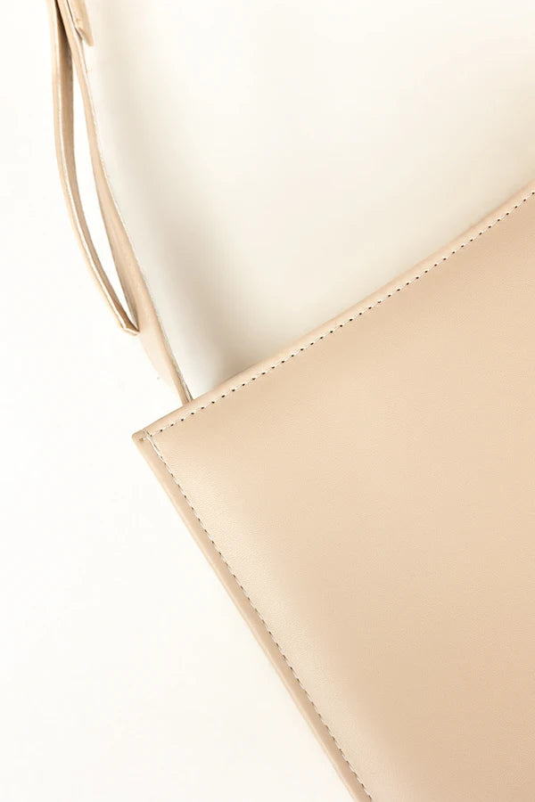 Close-up of a beige handbag with a white background