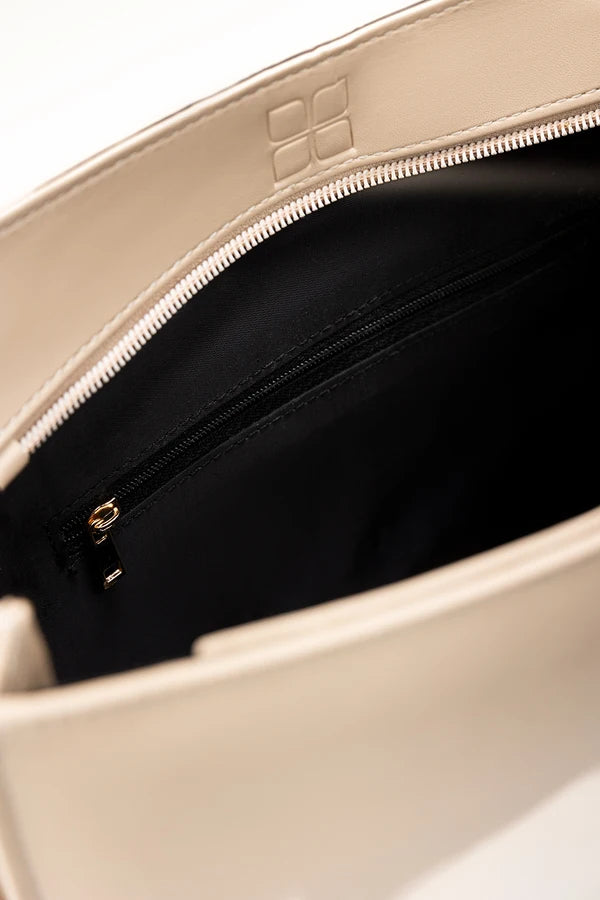 Beige handbag with a zipper, showing the brand logo on a white background