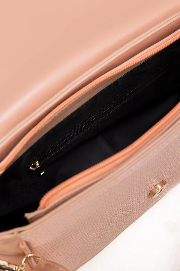 Close-up of a pink handbag with a gold zipper on a white background