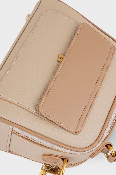 Beige handbag with gold accents on a light gray background