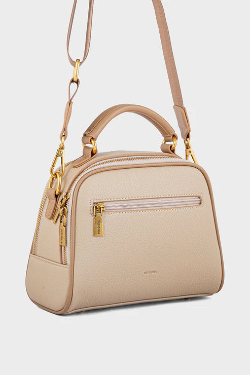 Beige handbag with gold accents on a light gray background