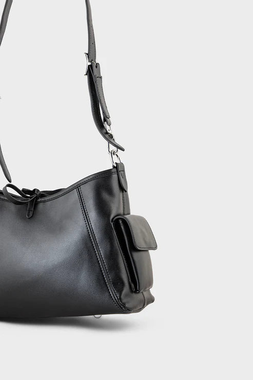 Black handbag with a strap on a light gray background