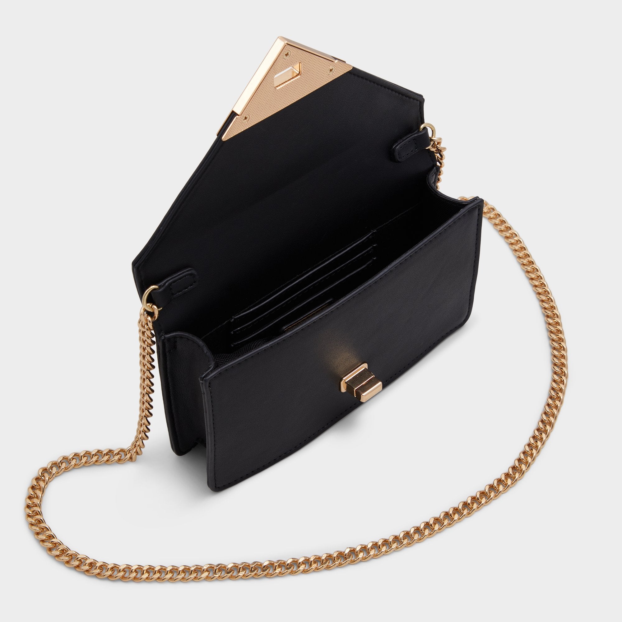 Black handbag with gold chain strap on a light gray background