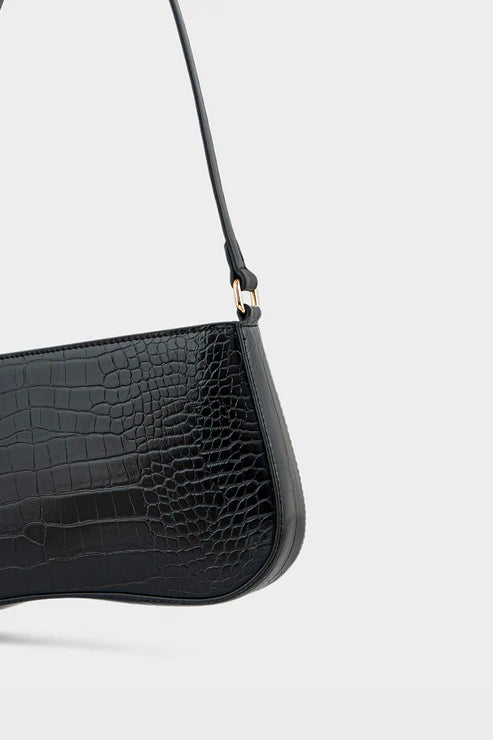 Black crocodile-textured handbag with a strap on a light gray background