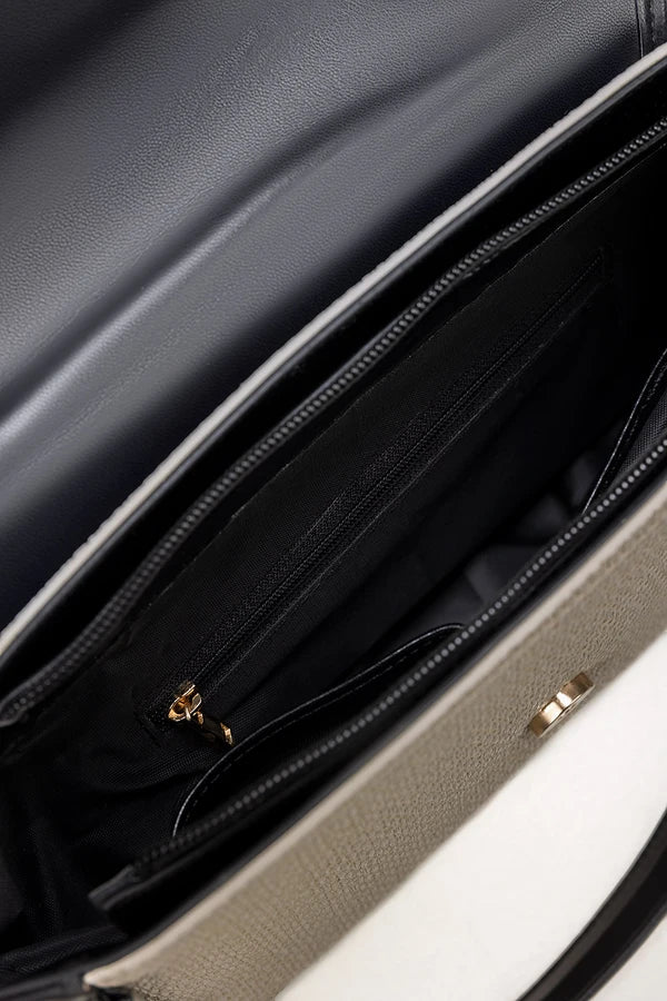 Close-up of a black leather bag with gold zipper pullers.