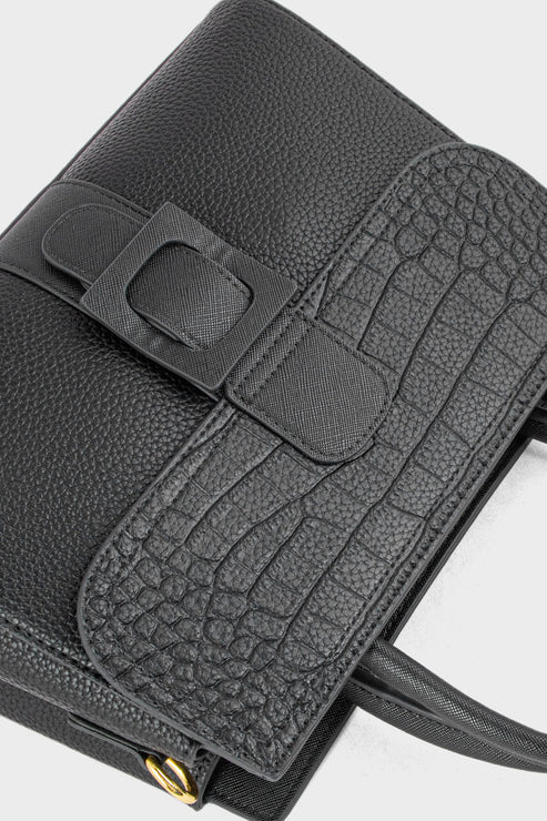 Black leather handbag with a buckle detail on a white background