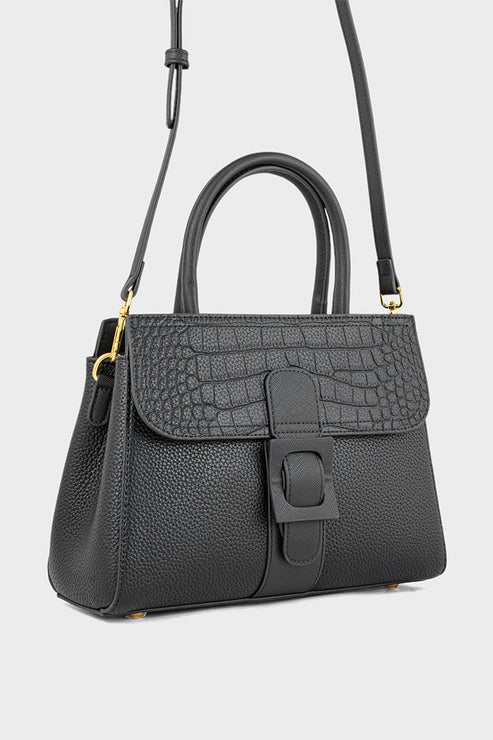 Black handbag with a textured surface and gold accents on a light gray background