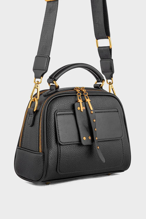 Black handbag with gold accents on a light gray background