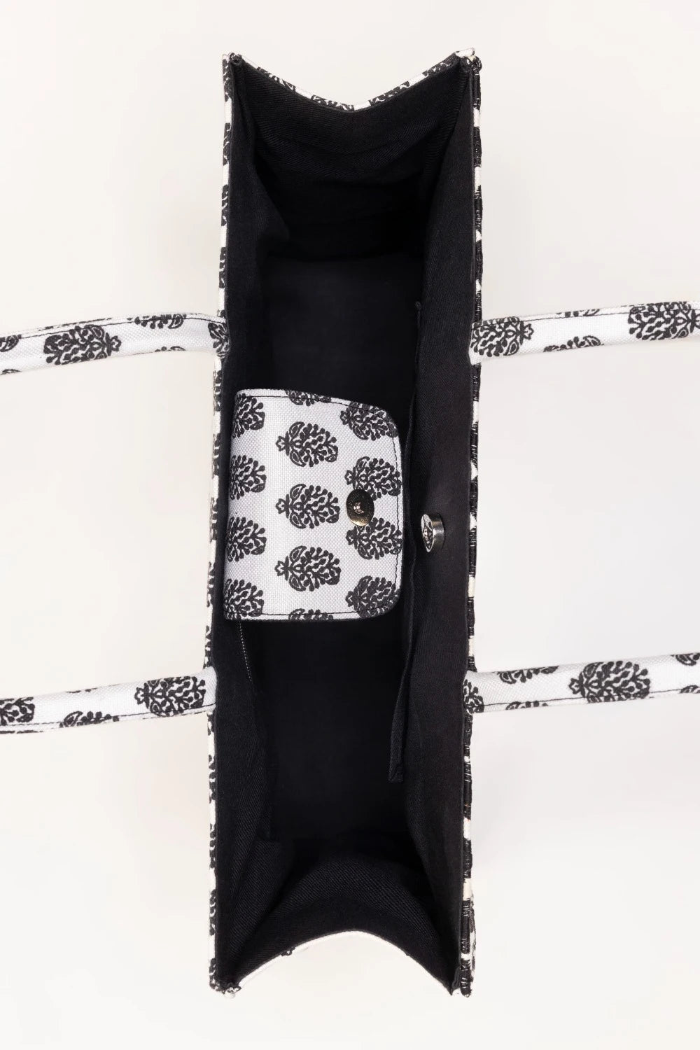 Black textured bag with a white patterned phone inside on a white background