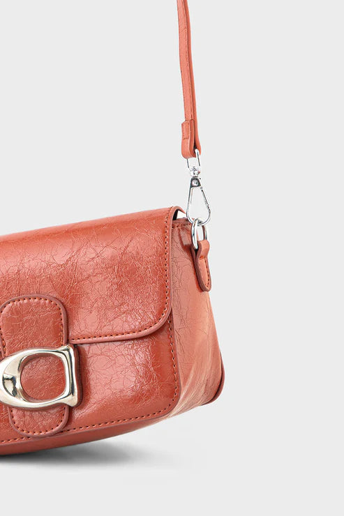 Brown leather handbag with a silver clasp on a light gray background