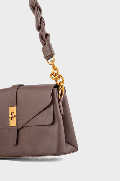 Brown handbag with braided handle and gold accents on a white background