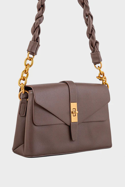 Brown handbag with braided handle and gold chain on a light gray background