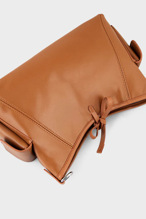 Brown leather bag with a drawstring on a light gray background