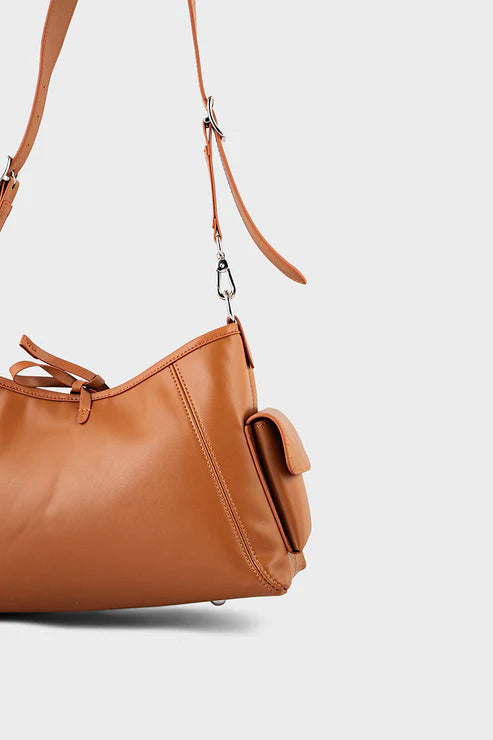 Brown leather handbag with a shoulder strap on a light gray background