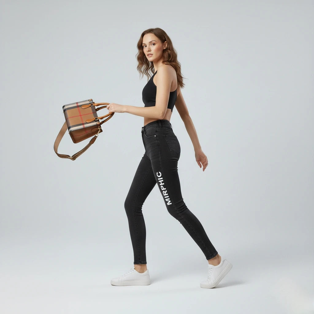 Woman holding a plaid handbag wearing black jeans with 'MIRPHIC' branding.