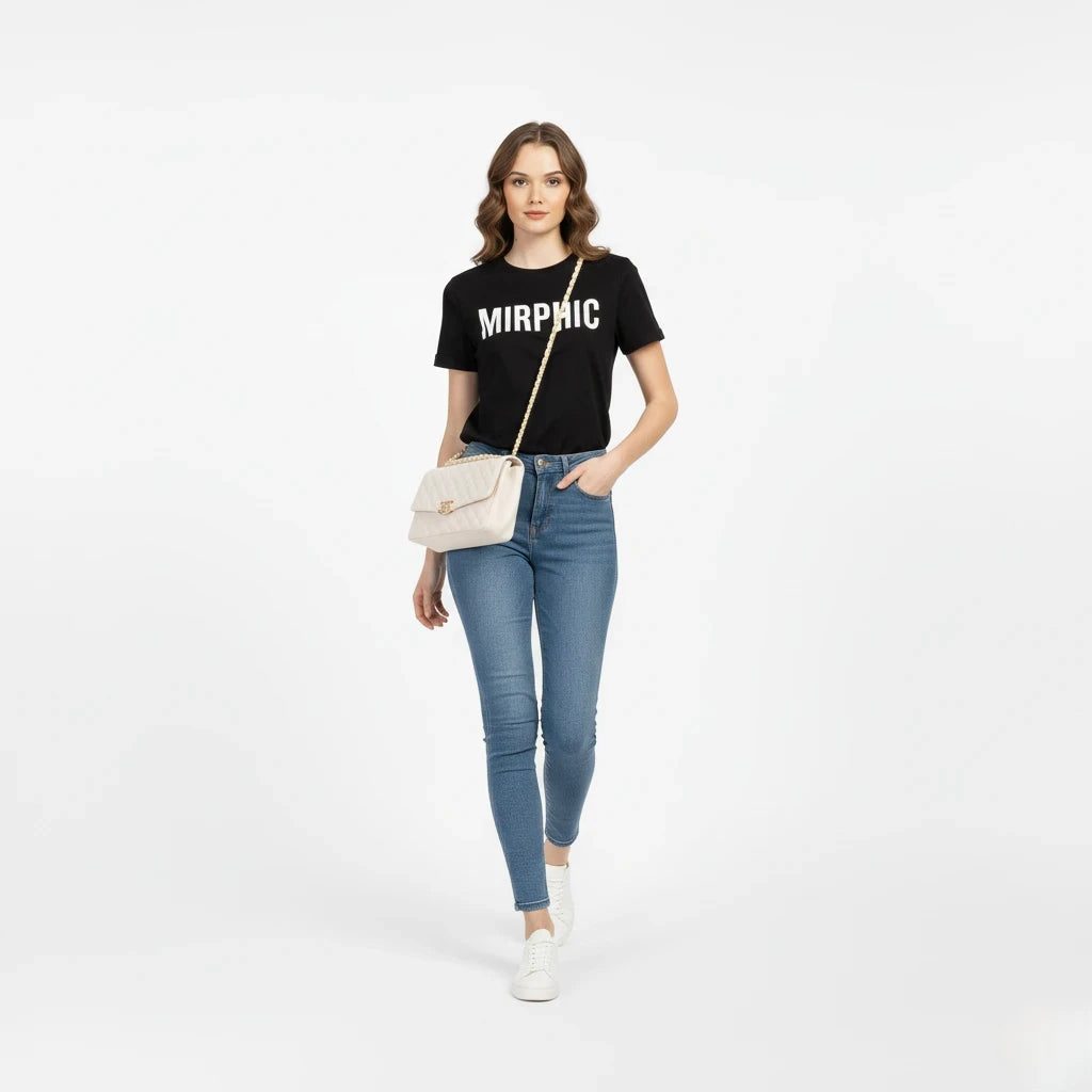 Woman wearing a black t-shirt with 'MIRPHIC' text, blue jeans, and white sneakers on a white background.
