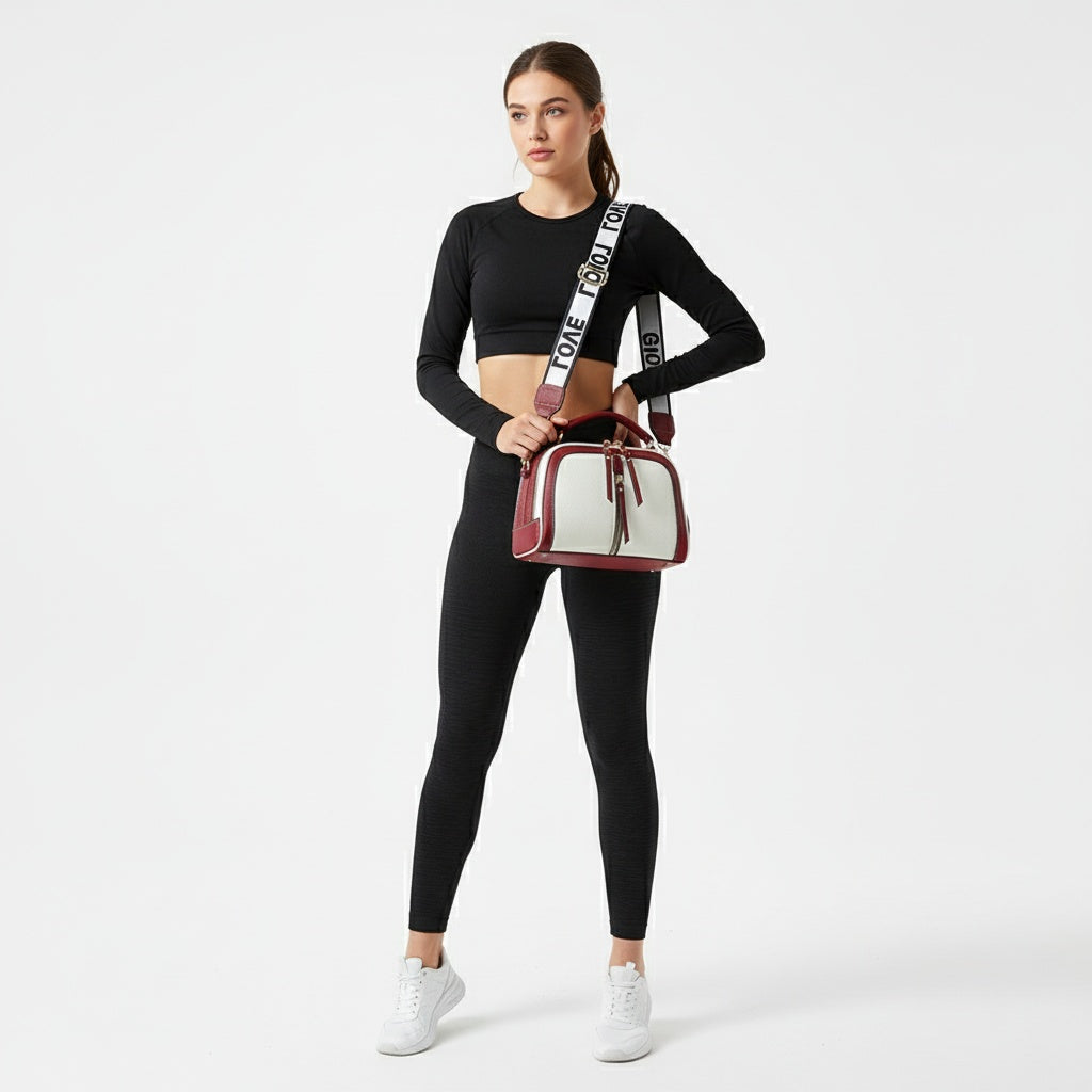 Woman holding a red and white handbag wearing a black outfit on a white background