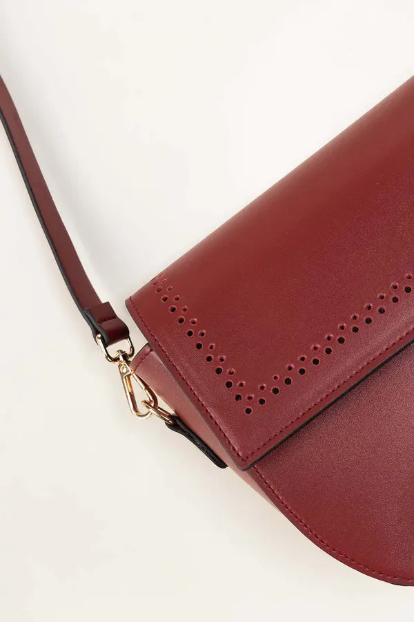 Red handbag with perforated detail on a white background