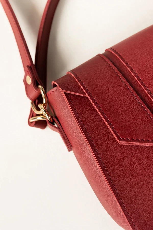 Red handbag with a gold clasp on a light background