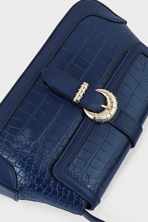 Blue crocodile-patterned handbag with a gold clasp on a light gray background