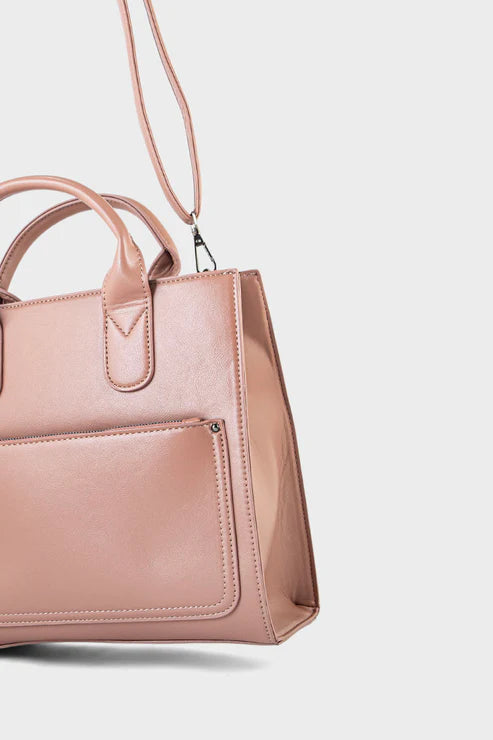 Pink handbag with a strap on a light gray background