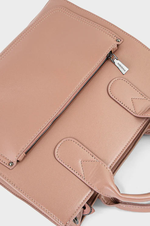 Close-up of a pink leather handbag with a visible brand tag on a white background