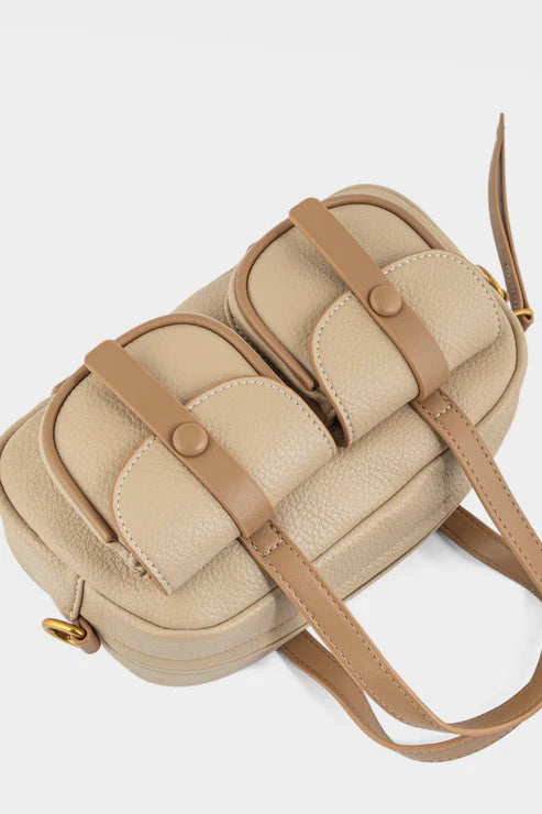Beige handbag with brown straps on a light gray background