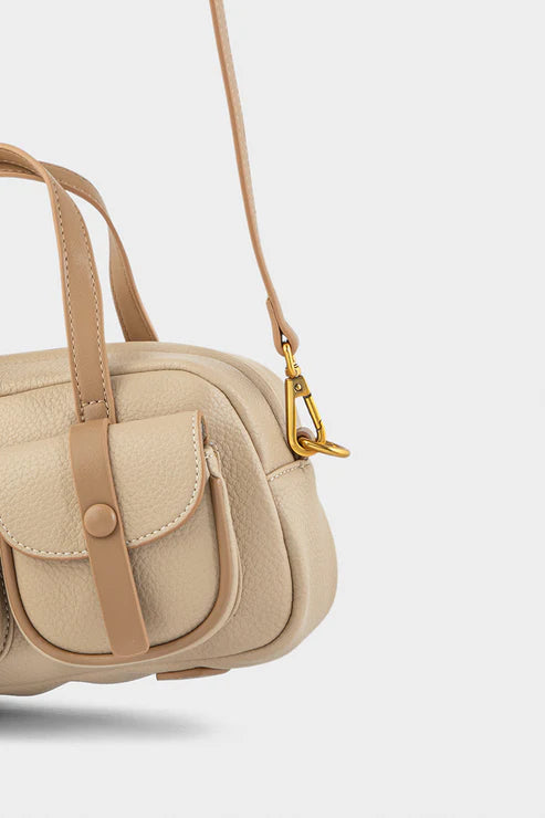 Beige handbag with brown straps on a light gray background