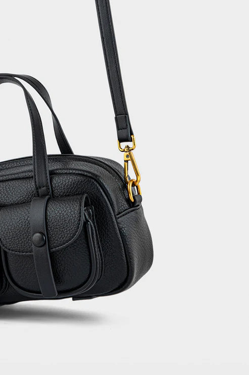 Black handbag with a gold clasp on a light gray background