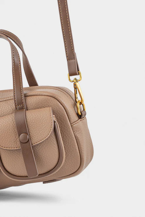 Beige handbag with brown straps on a light gray background