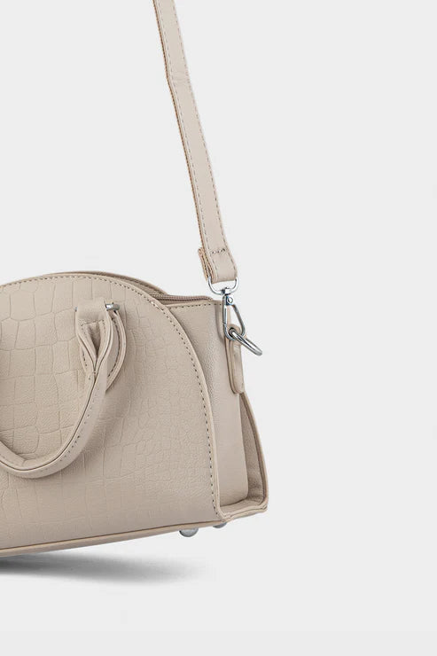 Beige handbag with a crocodile texture on a light gray background