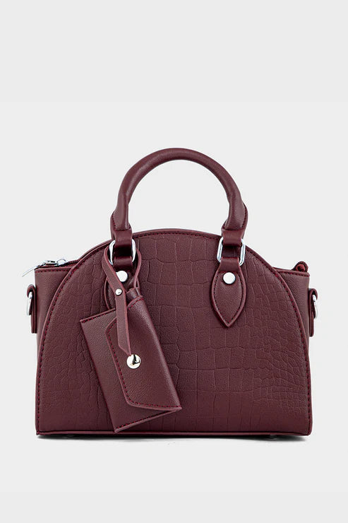 Maroon handbag with a matching pouch on a light gray background