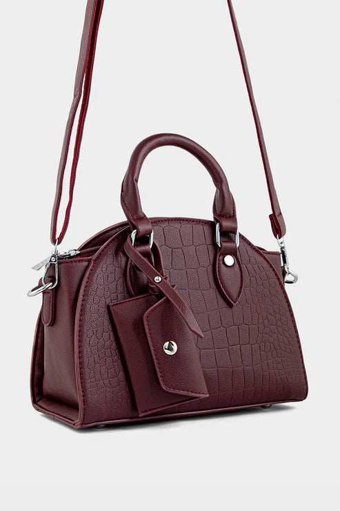 Maroon handbag with a matching pouch on a light gray background