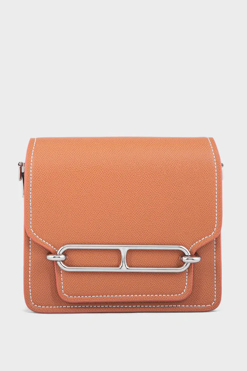 Orange handbag with a silver clasp on a light gray background