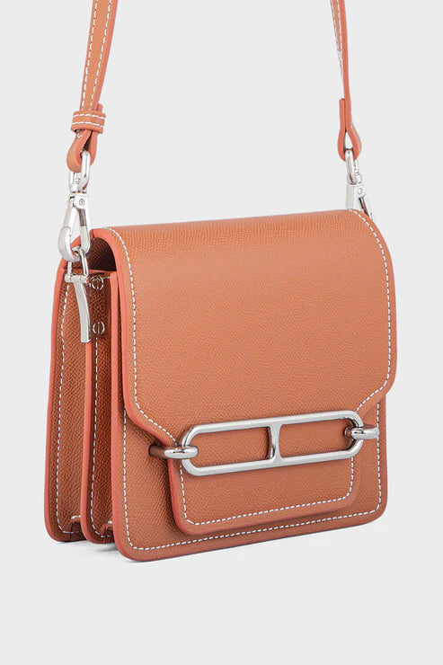 Brown crossbody bag with silver clasp on a white background