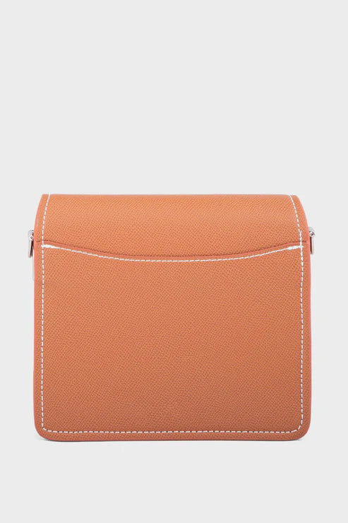 Orange handbag with white stitching on a light gray background