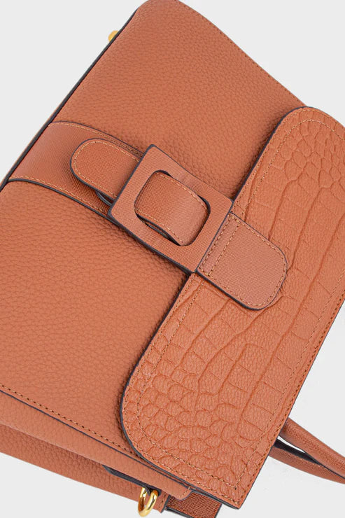 Brown leather handbag with a buckle detail on a light gray background