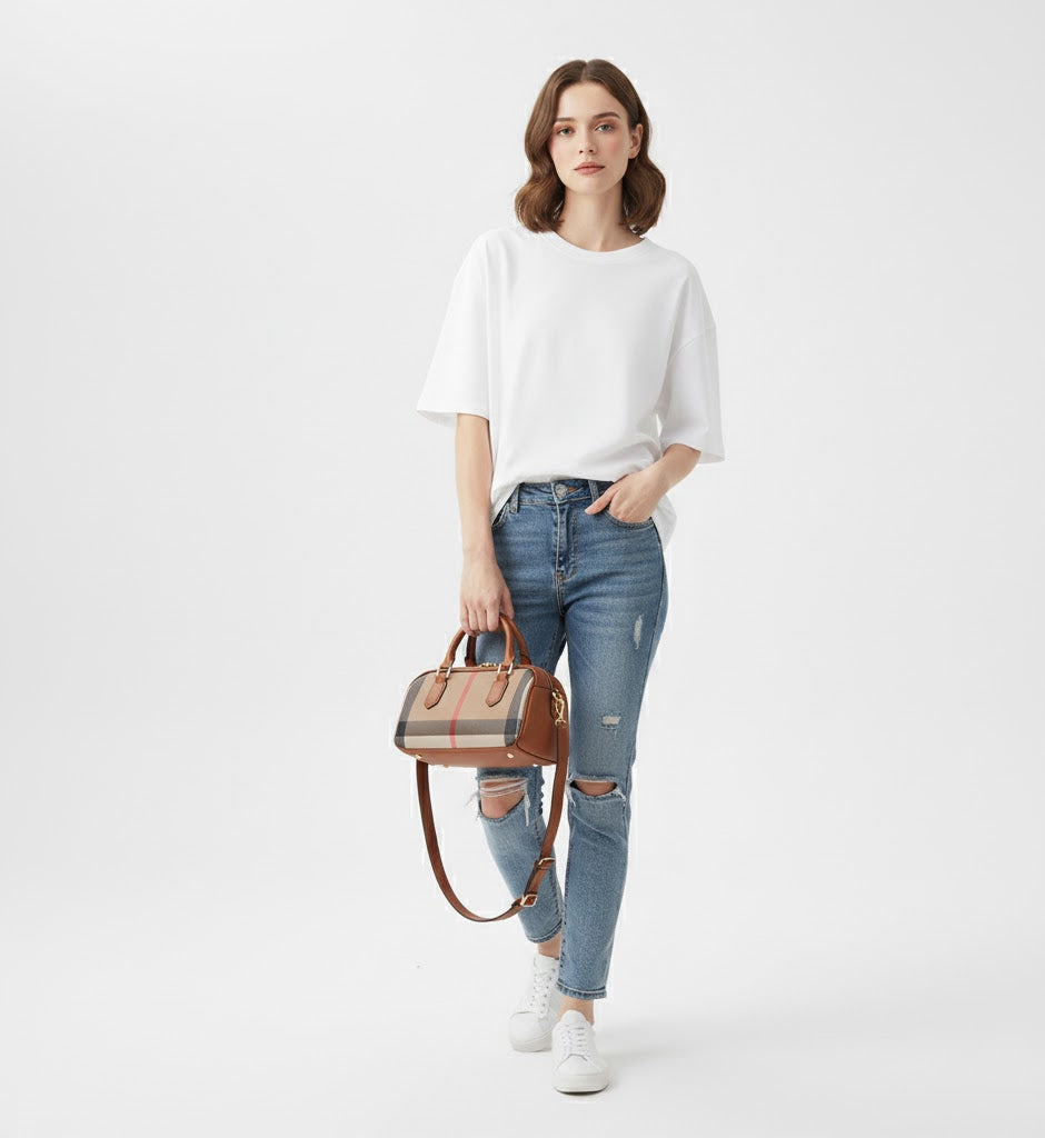 Woman holding a checkered handbag wearing a white top and blue jeans on a white background