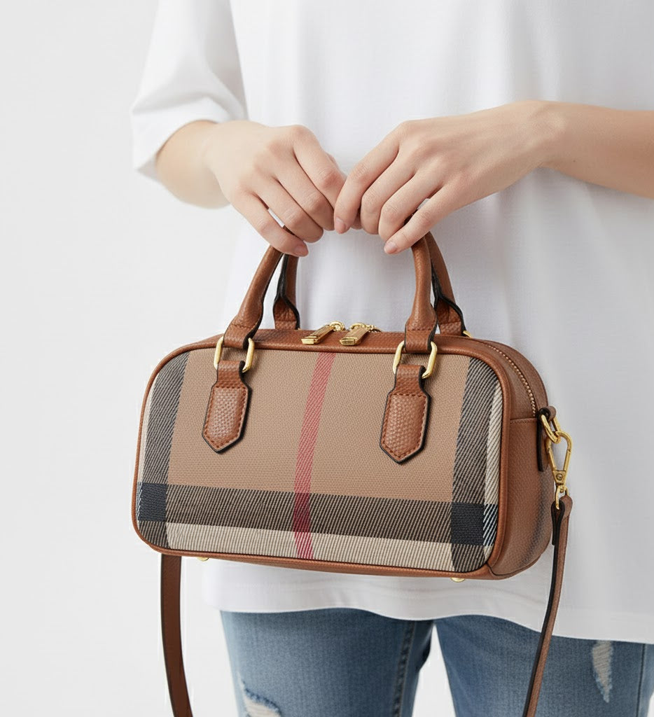 Person holding a brown handbag with plaid pattern on a white background