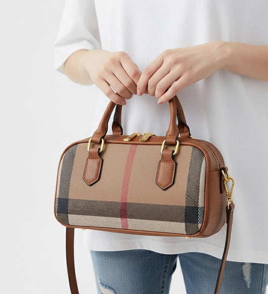 Person holding a brown handbag with plaid pattern on a white background