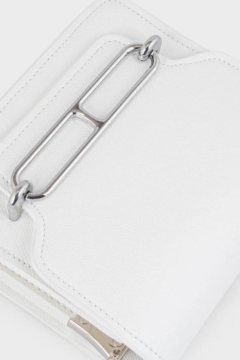 Close-up of a white handbag with a silver metal clasp on a light gray background