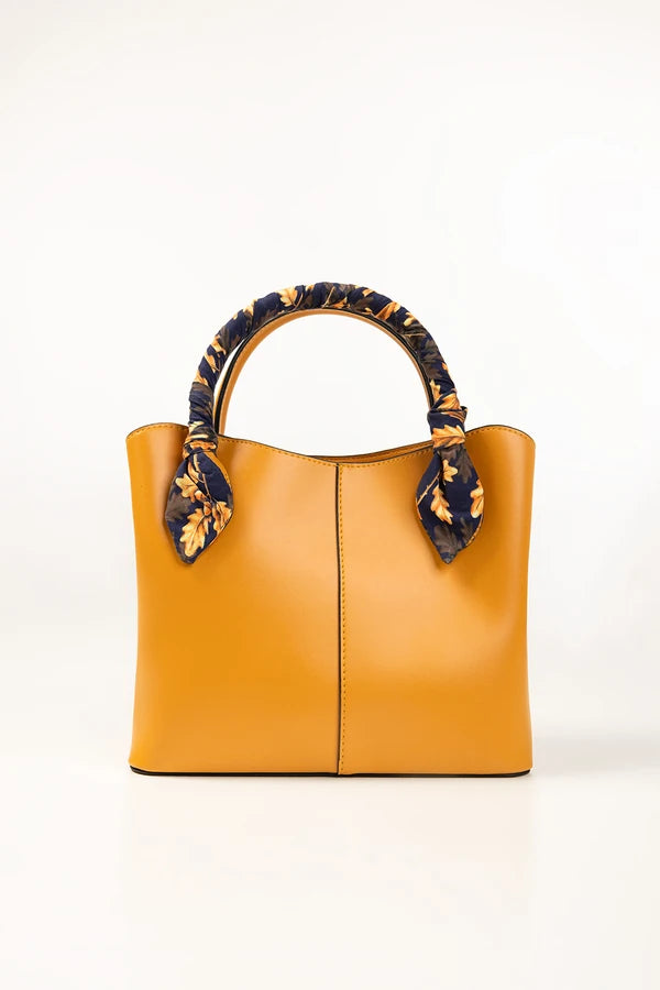 Yellow handbag with decorative handles on a white background