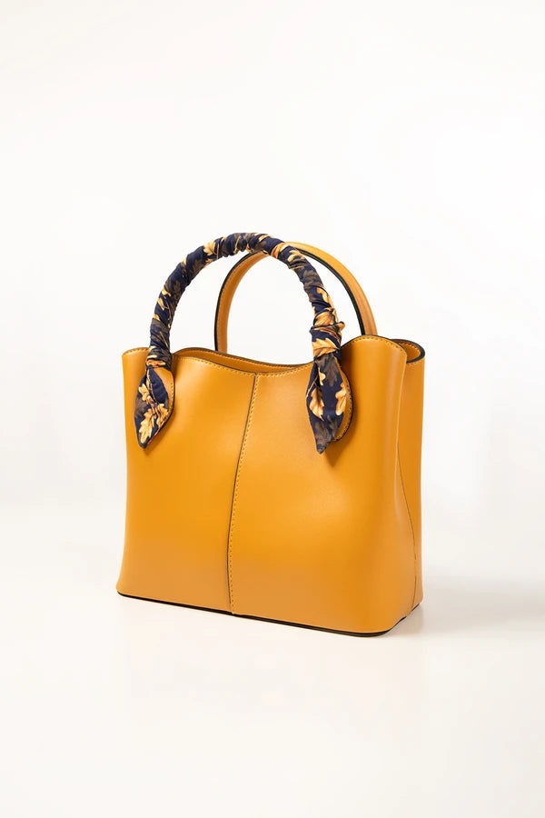 Yellow handbag with decorative handles on a white background