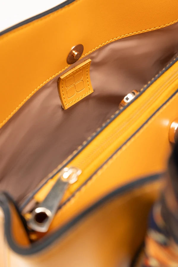 Close-up of a brown leather handbag with visible stitching and hardware.